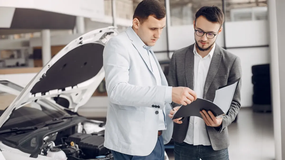 Muž si prohlíží auto v autosalonu