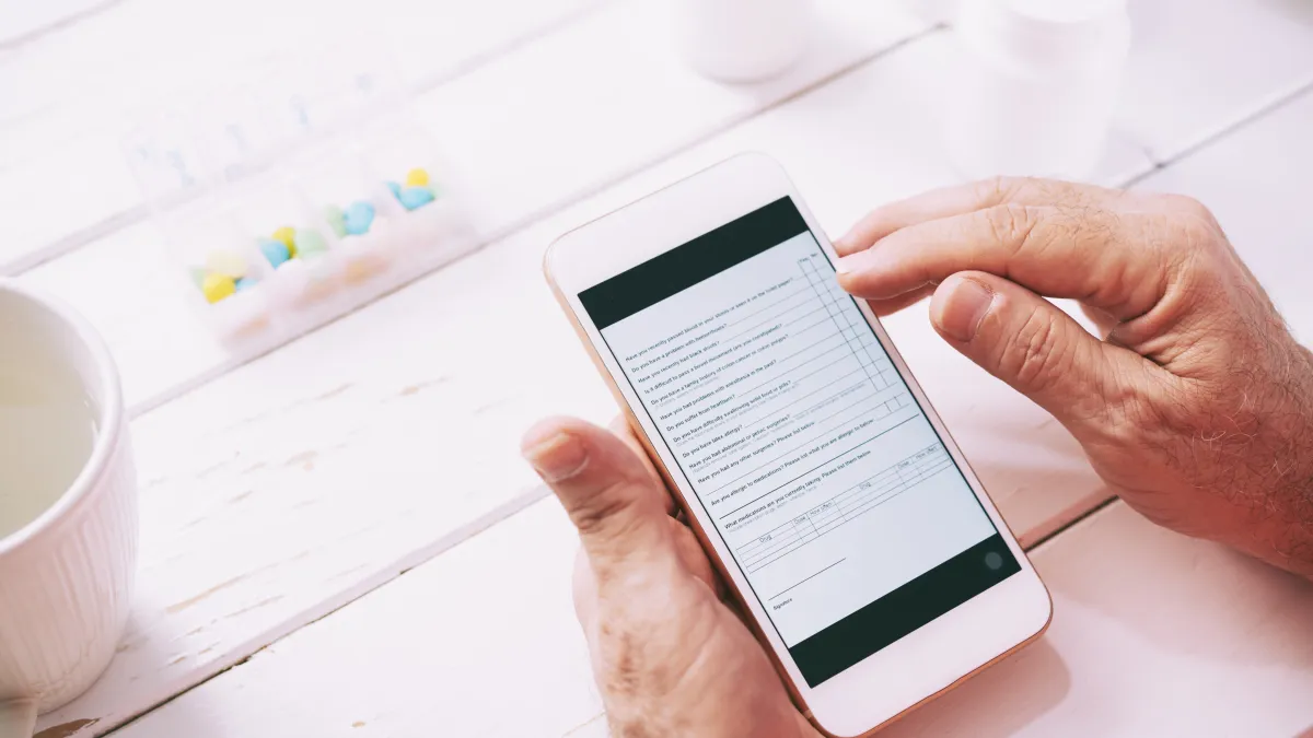 Ruce vyplňují formulář v mobilu