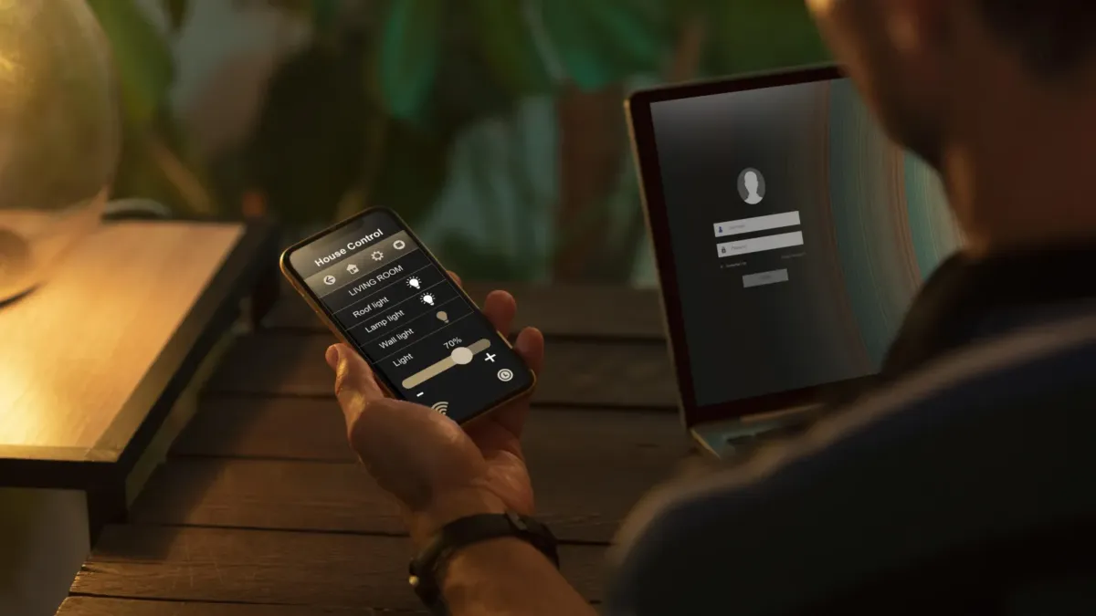Člověk ovládá chytrý telefon v přítmí domova
