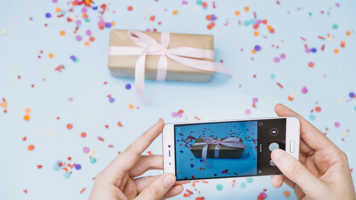 Ruka fotí mobilem dárkovou krabici