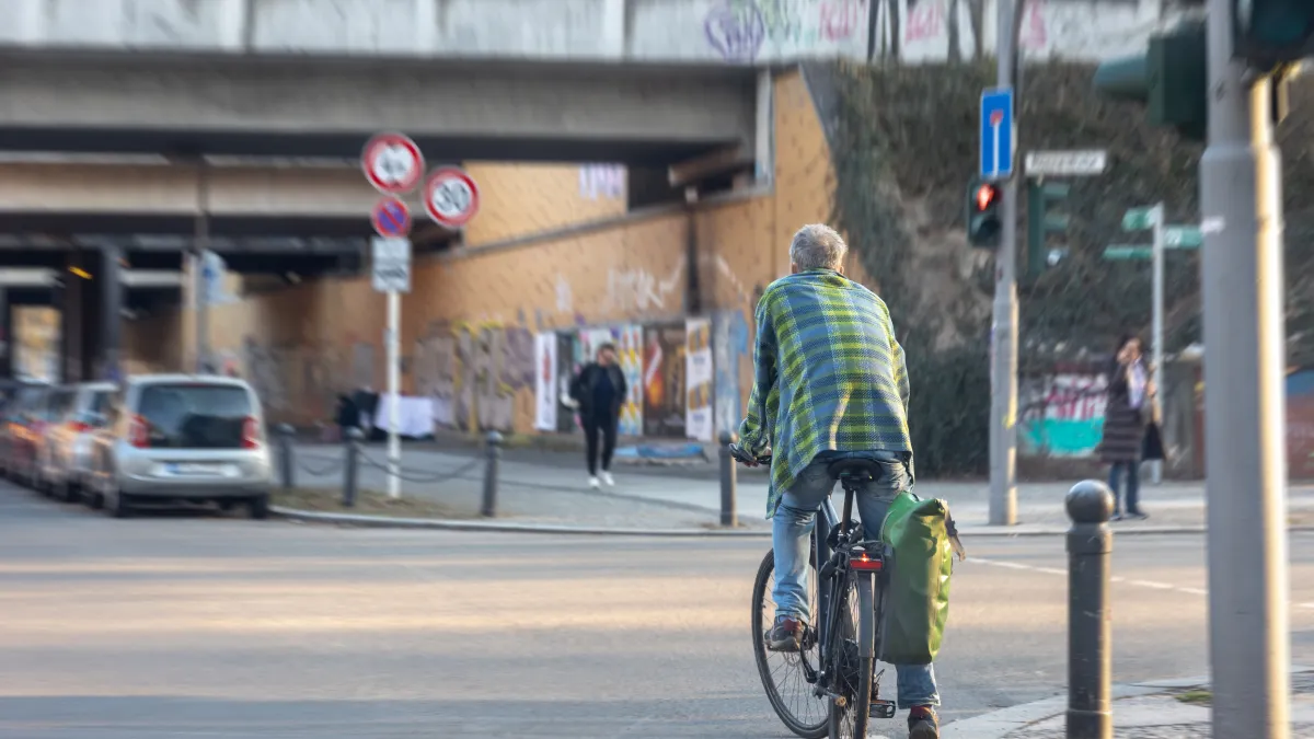 Cyklista na městské ulici mezi auty
